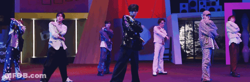 Group Of Men Dancing On Stage In Front Of Purple Background GIF