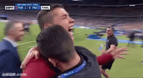 Group Of Men Hugging On Soccer Field GIF