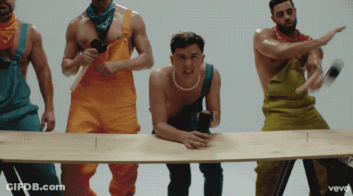 Group Of Men In Colorful Overalls Around Table With Vevo GIF