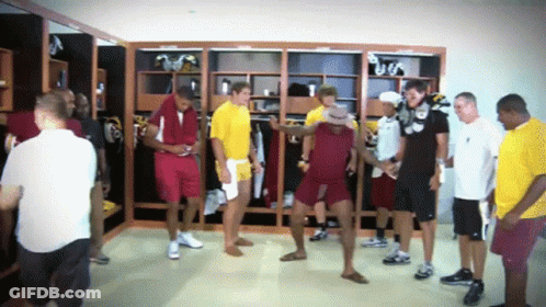 Group Of Men In Locker Room One Wearing Hat GIF