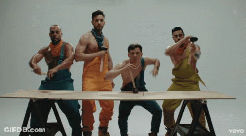Group Of Men In Overalls Around Table With Vevo GIF