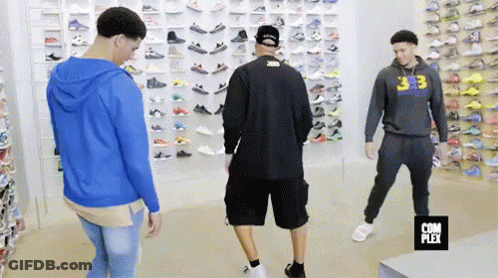Group Of Men In Shoe Store Looking At Shoes GIF