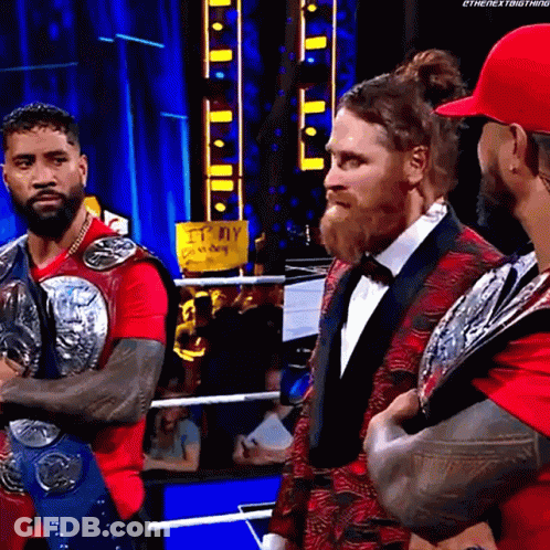Group Of Men In Wrestling Ring With Red Shirt GIF