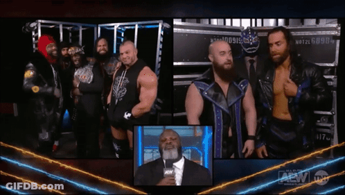 Group Of Men Next To Man In Suit With AEW Logo GIF