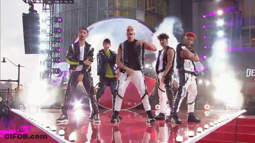 Group Of Men On Stage With Sign Saying De GIF