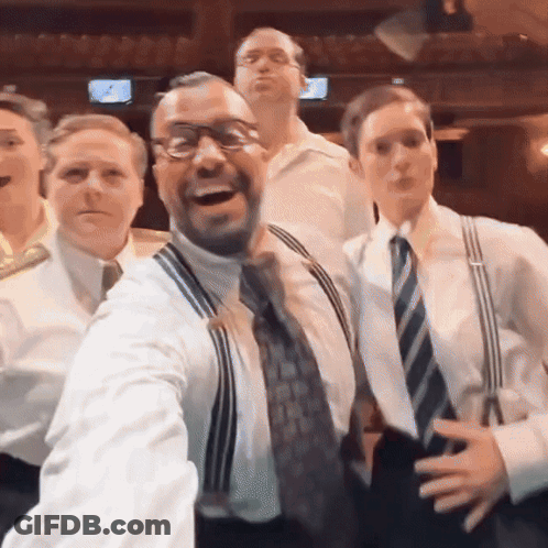 Group Of Men Posing One In Suspenders GIF