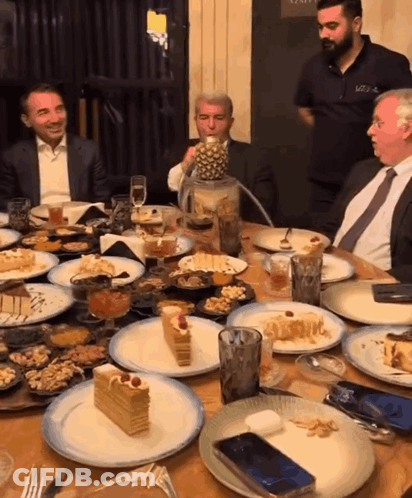 Group Of Men Sitting At Table With Food And Drinks GIF