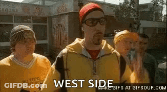 Group Of Men Standing In Front Of Building One Wearing Glasses And Red Hat GIF