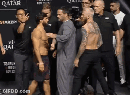 Group Of Men Standing In Front Of Qatar Sign GIF