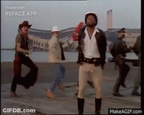 Group Of Men Walking Down Street One Wearing Helmet GIF