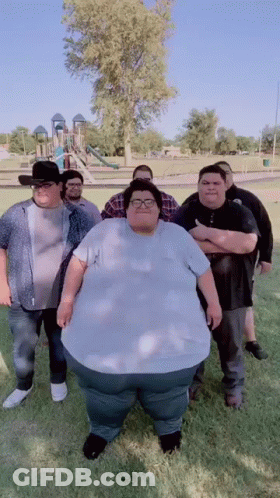 Group Of Men With Very Large Man In Park GIF