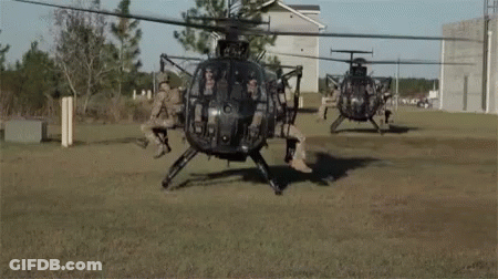 Group Of Military Helicopters In A Field GIF