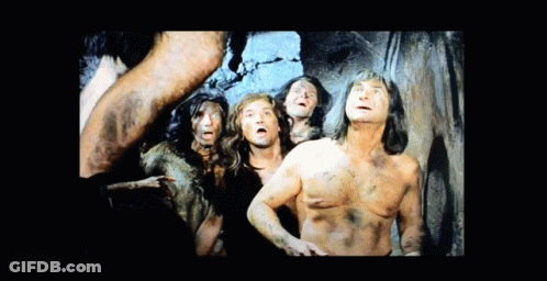 Group Of Naked Men Standing Before Cave Wall GIF