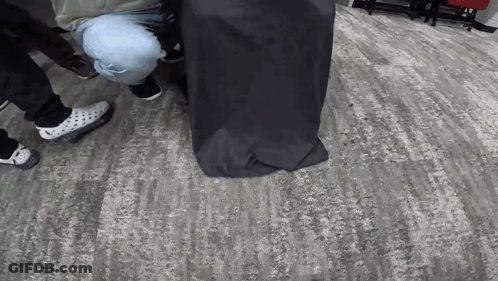 Group Of People Around Black Bag GIF
