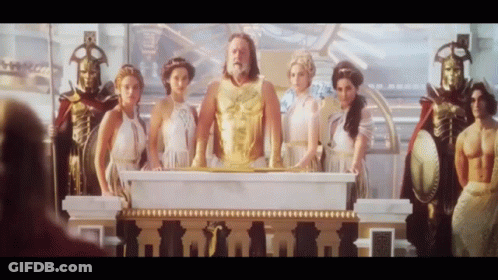 Group Of People Around Podium With Man In Gold Vest GIF