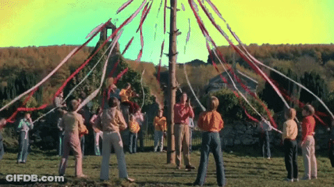 Group Of People Around Pole With Ribbons GIF