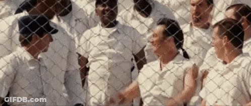 Group Of People Behind Chain Link Fence GIF