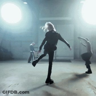 Group Of People Dancing In Dark Room With Spotlight GIF