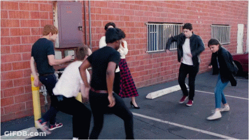 Group Of People Dancing In Front Of Brick Building GIF