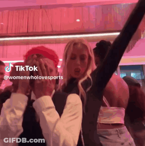 Group Of People Dancing On Pink Background With TikTok Logo GIF