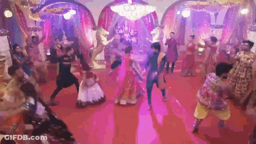 Group Of People Dancing On Red Carpet Under Purple Lights GIF