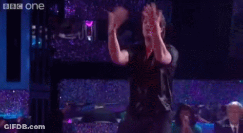 Group Of People Dancing On Stage In Front Of BBC One Sign GIF