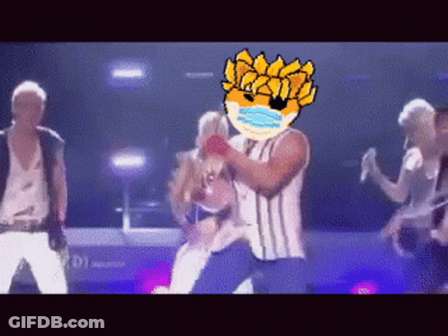 Group Of People Dancing On Stage With Man In Mask GIF