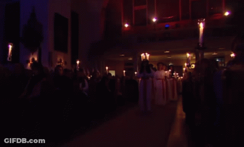 Group Of People Holding Candles In Dark Room GIF