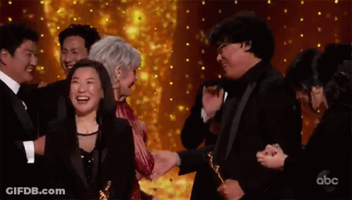 Group Of People Holding Trophies On Stage GIF