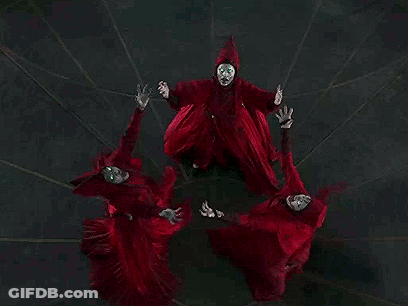 Group Of People In Red Robes Standing In Circle GIF