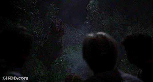Group Of People Looking At Dinosaur In Dark Forest GIF