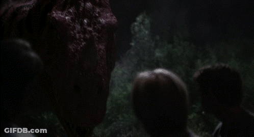 Group Of People Looking At Large Red Monster In Dark GIF