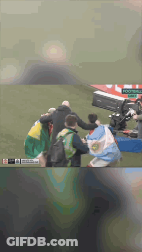 Group Of People On Field With Sign Saying Football GIF