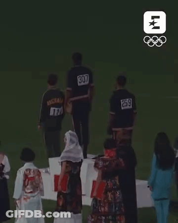 Group Of People On Podium With Numbers On Backs GIF