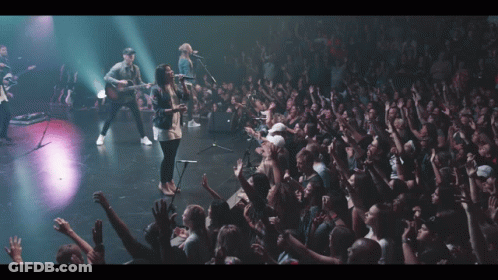 Group Of People On Stage With Hands Up GIF