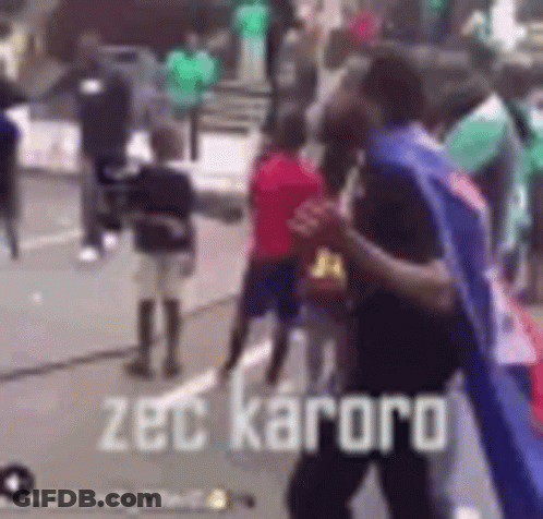 Group Of People On Street With Zec Kaoro Text GIF