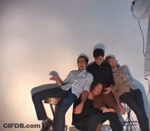 Group Of People Posing For Picture In Room With White Wall GIF