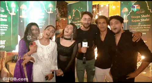 Group Of People Posing With Man Holding Microphone GIF