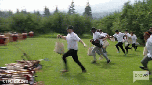 Group Of People Running In Field With Bravo Logo GIF