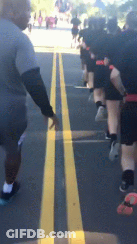 Group Of People Running On Street With Yellow Line GIF