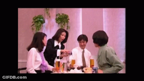Group Of People Sitting Around Table With Drinks And Food GIF