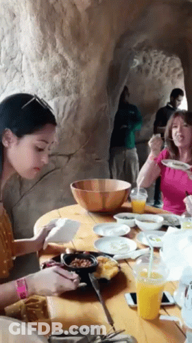 Group Of People Sitting At Table With Food And Drinks GIF