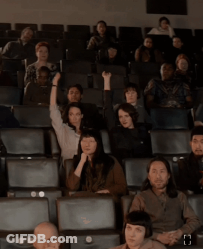 Group Of People Sitting In Theater With Letter H GIF