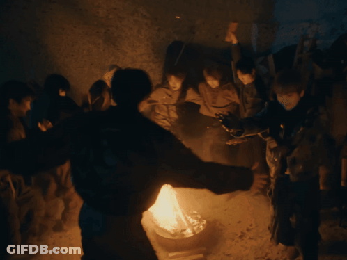 Group Of People Standing Around Fire GIF