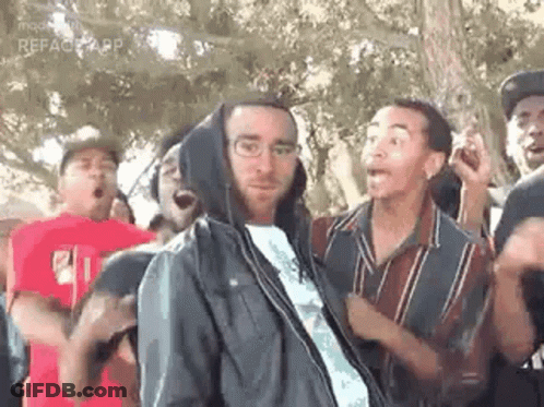 Group Of People Standing Around Man In Hoodie GIF