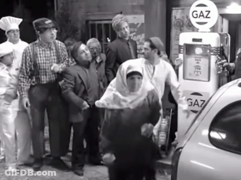 Group Of People Standing At Gas Pump GIF