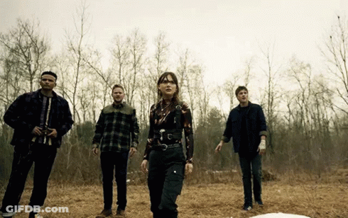Group Of People Standing In Field With Trees GIF