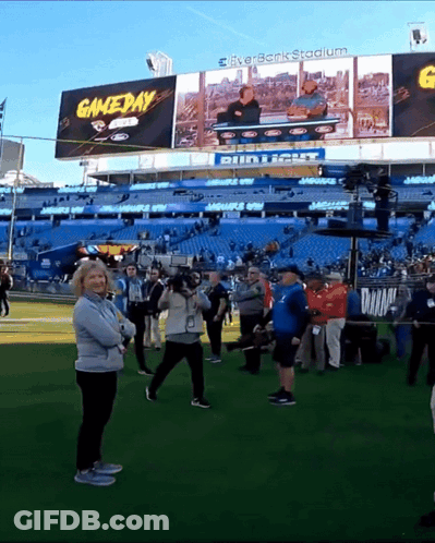 Group Of People Standing In Front Of Gameday Stadium GIF