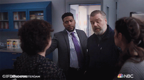 Group Of People Standing In Room With NBC Logo GIF