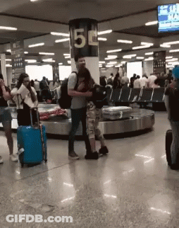 Group Of People Standing In Room With Sign Saying 5 GIF